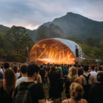 Cena ilustrativa de festival de música ao ar livre em uma área verde de Petrópolis