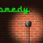 Palco de clube de comédia com microfone, iluminação neon e ambiente de apresentação de stand-up